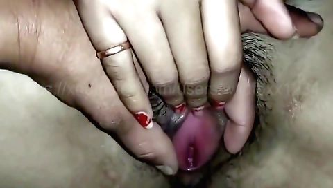 Indian girl with a huge bush and a shaved pussy plays with a cock