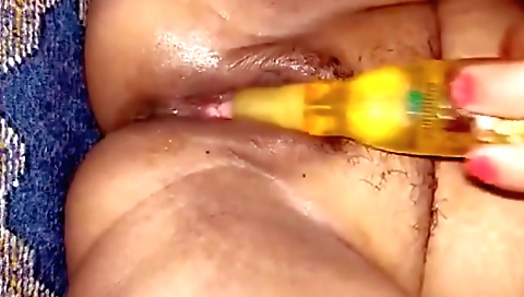 A sexy indian is using her food to fill her hairy pussy